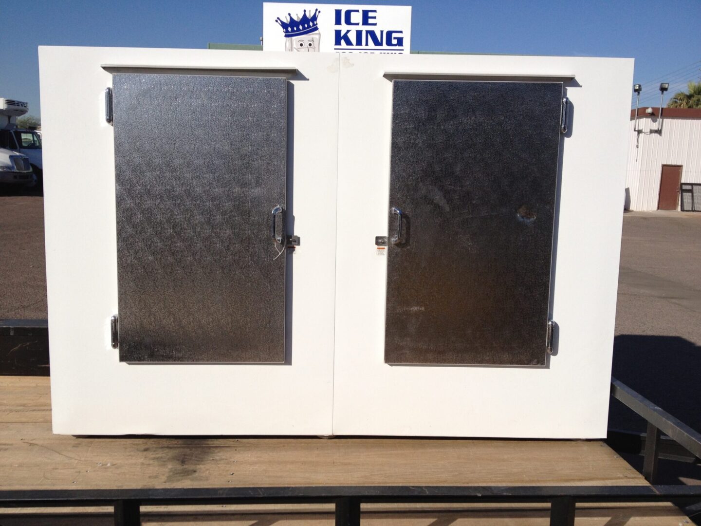 A white ice king freezer sitting on top of a platform.